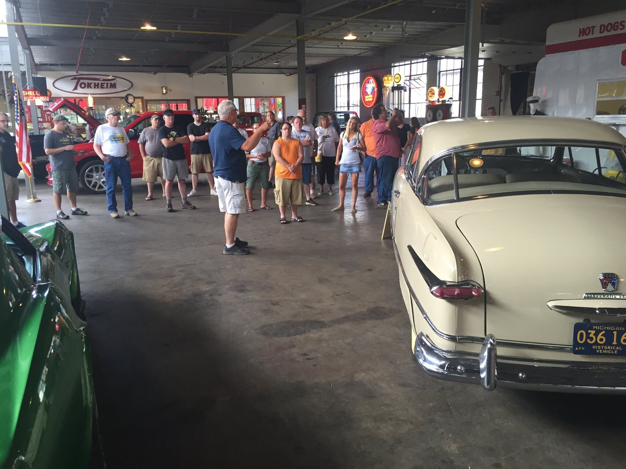 group of visitors gather near a car inside the museum